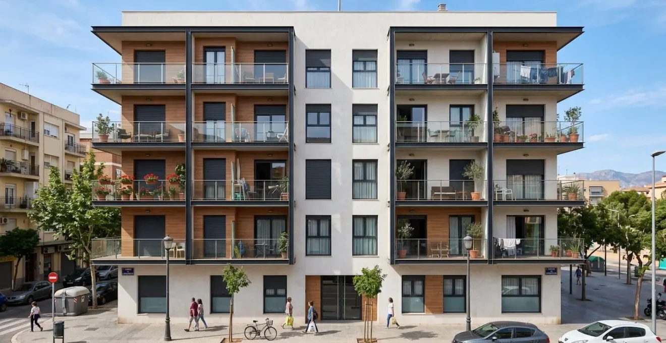 Fachada de un edificio residencial moderno español con balcones de cristal, arquitectura contemporánea y cielo azul